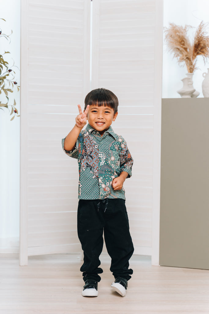 The print on the Kasih shirt is a blend of floral and miniature geometric shapes, which has the likes of the Sekar Jagad print. This short-sleeved button-up shirt features a classic collar, along with a front pocket. Made from premium cotton doby for a breathable and effortless drape, the shirt requires minimal to no ironing care. This print comes in 2 colours, black and winter green.